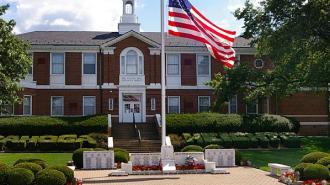 Cuyahoha Heights Village Hall municipal building with American flag in front.