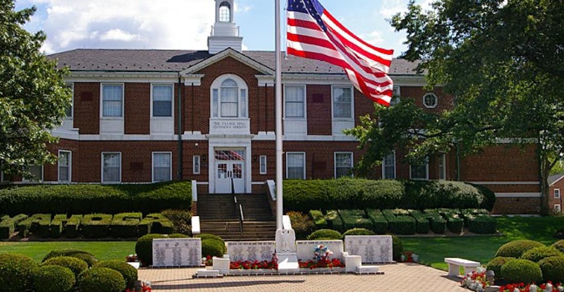 Cuyahoha Heights Village Hall municipal building with American flag in front.