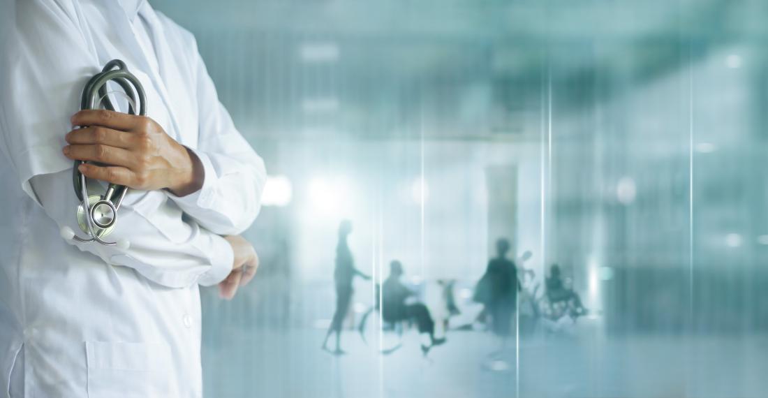 A doctor holding a stethoscope with the silhouettes of patients in the background.