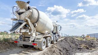 Cement truck driving through construction site.