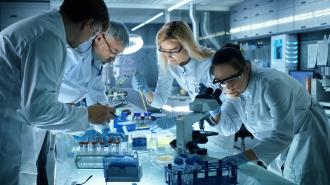 Scientists in a lab utilizing laboratory equipment.